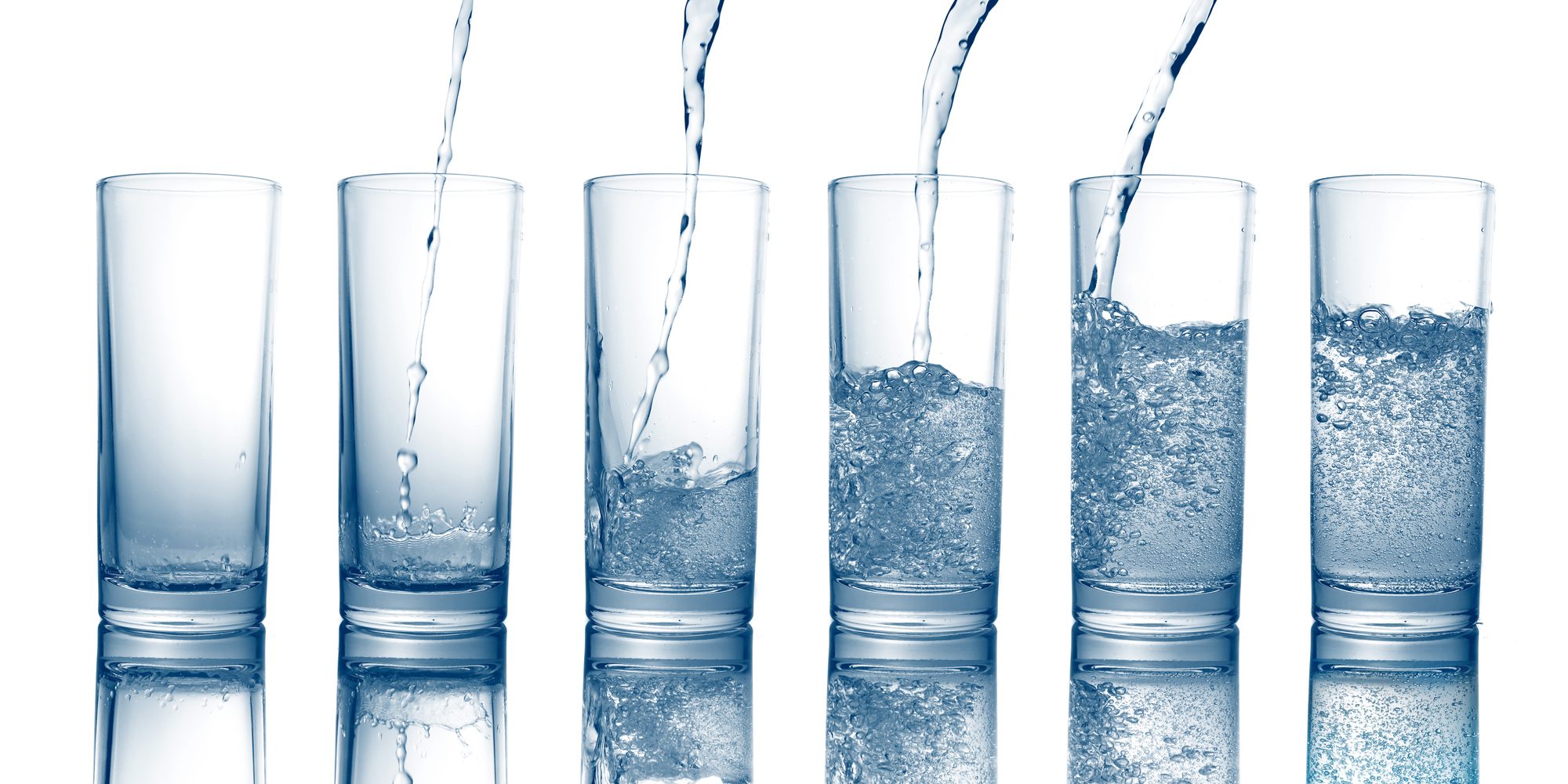 Pouring of fresh cool water in a glass isolated on white background